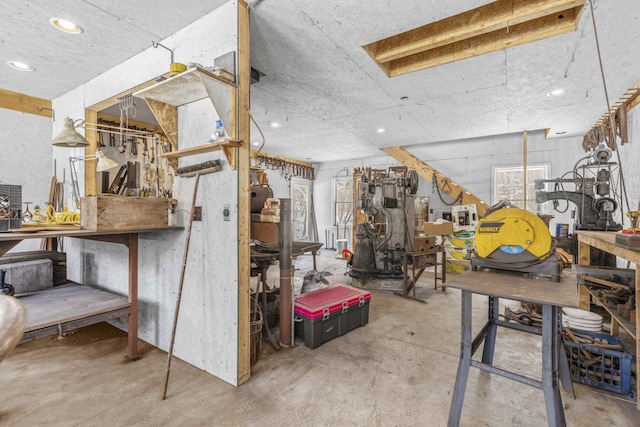 interior space featuring concrete flooring, a workshop area, and recessed lighting