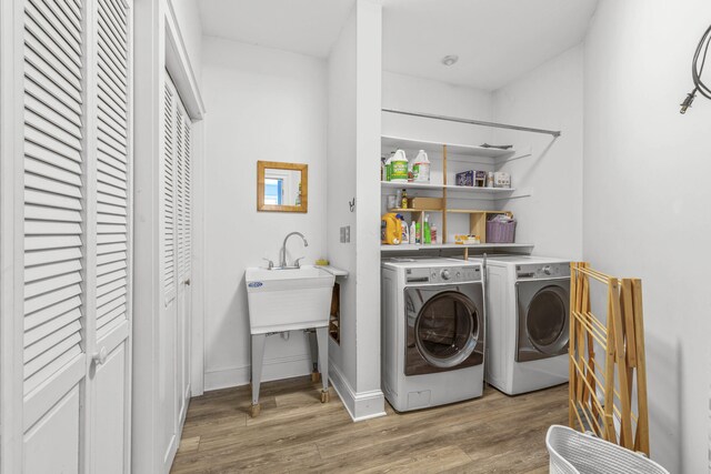 laundry room featuring baseboards, laundry area, independent washer and dryer, and wood finished floors
