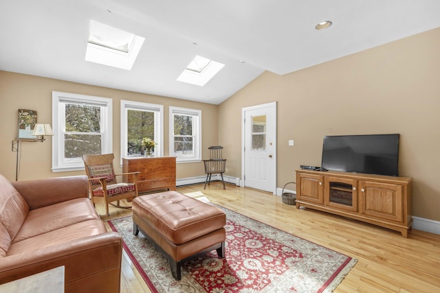 living room with vaulted ceiling with skylight, baseboard heating, baseboards, light wood-style floors, and recessed lighting