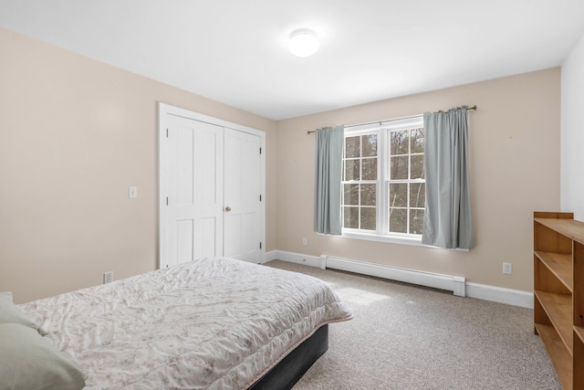 carpeted bedroom with a closet, baseboards, and a baseboard radiator