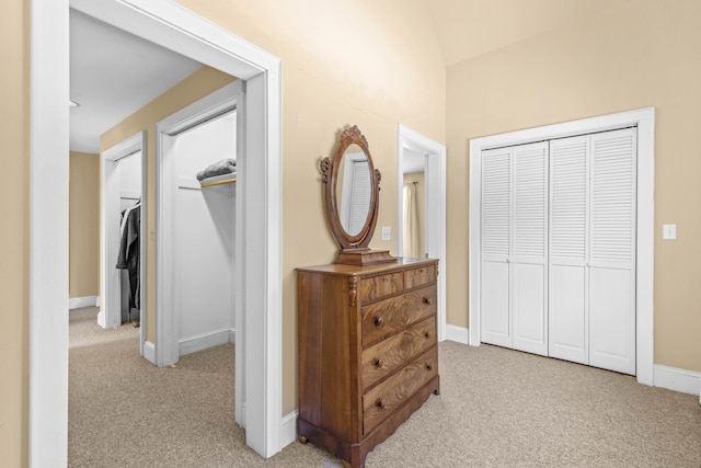 corridor with baseboards and light carpet