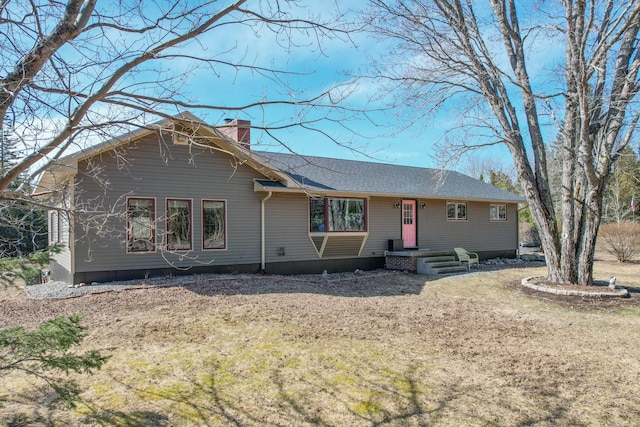 ranch-style house featuring roof with shingles and a chimney
