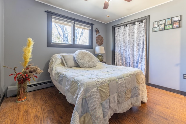 bedroom featuring ceiling fan, wood finished floors, and a baseboard radiator