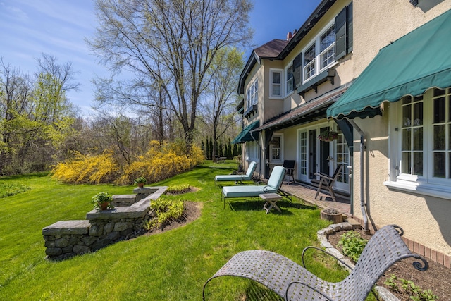 view of green lawn with french doors