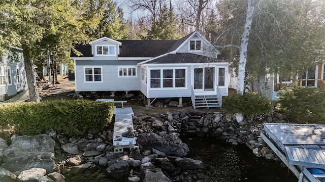 rear view of house with roof with shingles