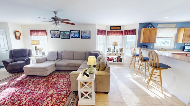 living room with baseboards and a ceiling fan