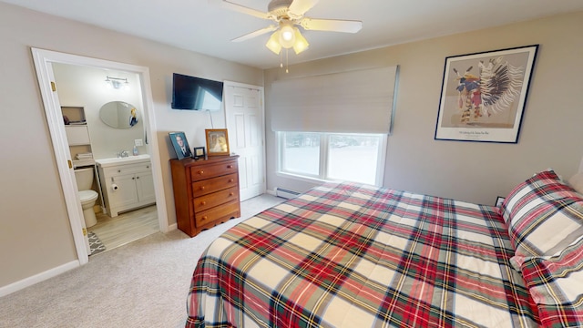 bedroom with ensuite bathroom, baseboards, ceiling fan, baseboard heating, and light carpet