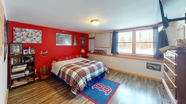 bedroom featuring baseboards and wood finished floors