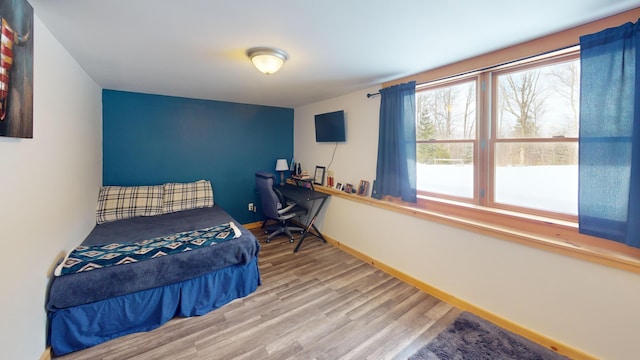 bedroom with baseboards and wood finished floors