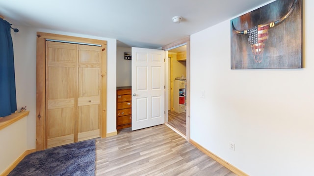 bedroom featuring baseboards, a closet, and light wood-style floors