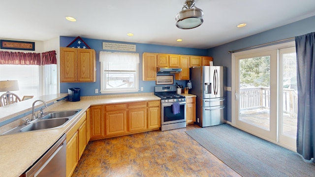 kitchen with a sink, a wealth of natural light, light countertops, and appliances with stainless steel finishes