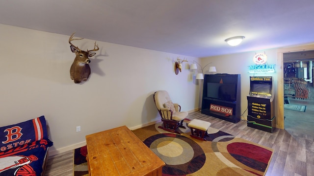 living area featuring baseboards and wood finished floors