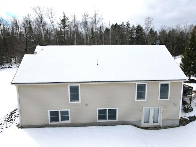 view of snow covered back of property