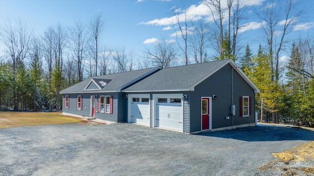 single story home with an attached garage, a shingled roof, and a front yard