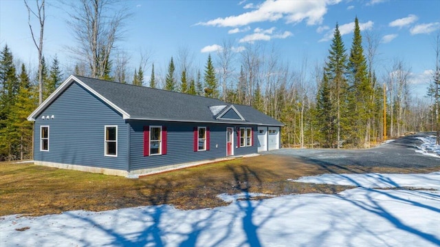 view of front of property featuring a garage, driveway, and a lawn