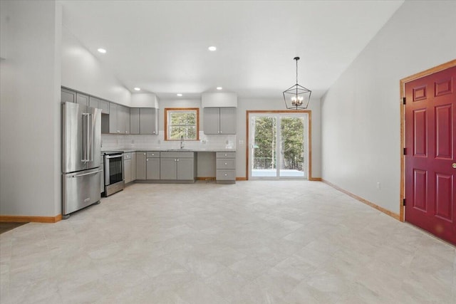 kitchen featuring baseboards, light countertops, stainless steel appliances, gray cabinets, and decorative backsplash