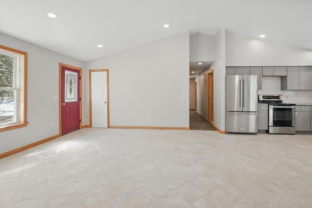 unfurnished living room featuring baseboards, lofted ceiling, and recessed lighting