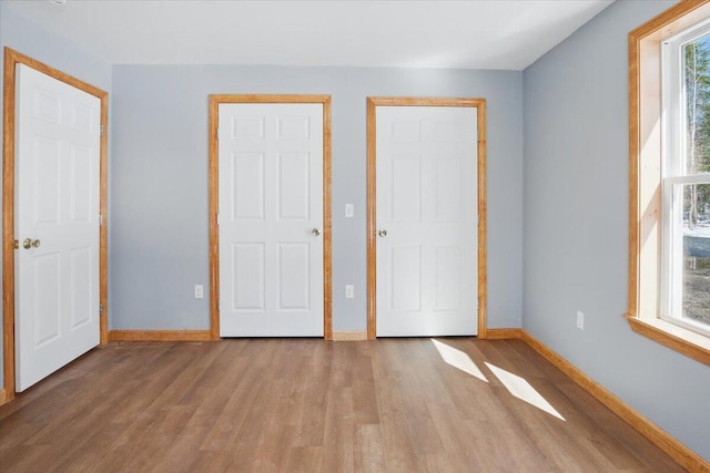 unfurnished bedroom with baseboards and light wood-style floors