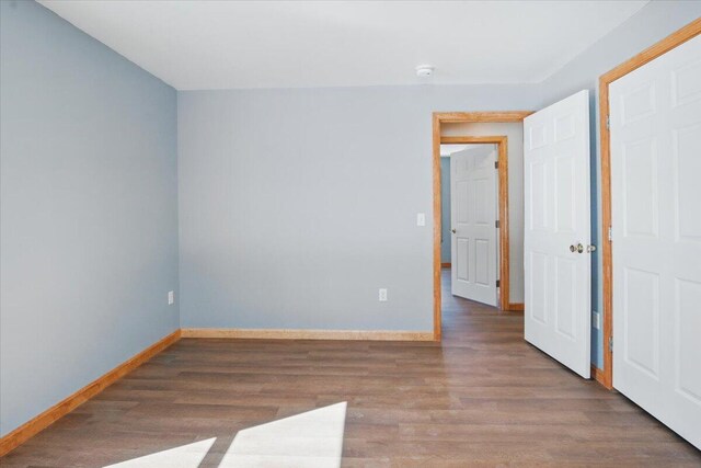 empty room featuring baseboards and wood finished floors