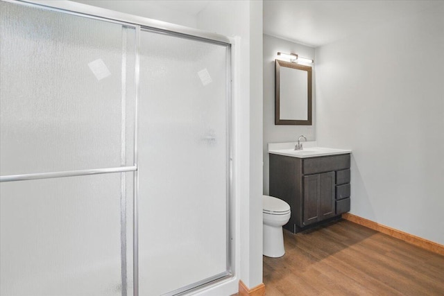 full bath with vanity, baseboards, a stall shower, toilet, and wood finished floors