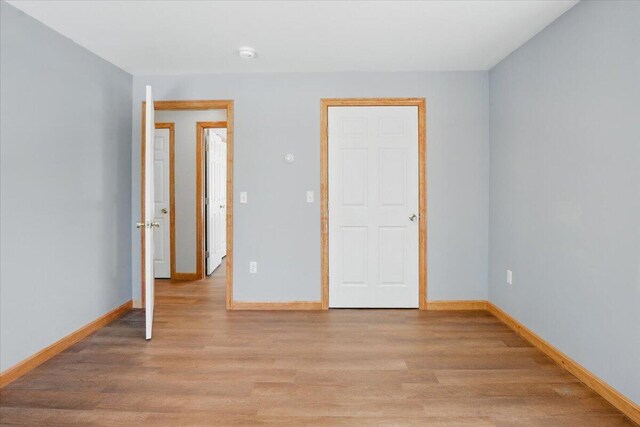 unfurnished bedroom featuring light wood-style flooring and baseboards