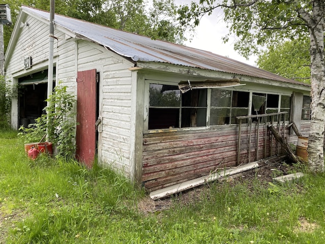 927 Van Buren Rd, Caswell, ME 04750 - view of side of home with an outbuilding, a garage, and metal roof