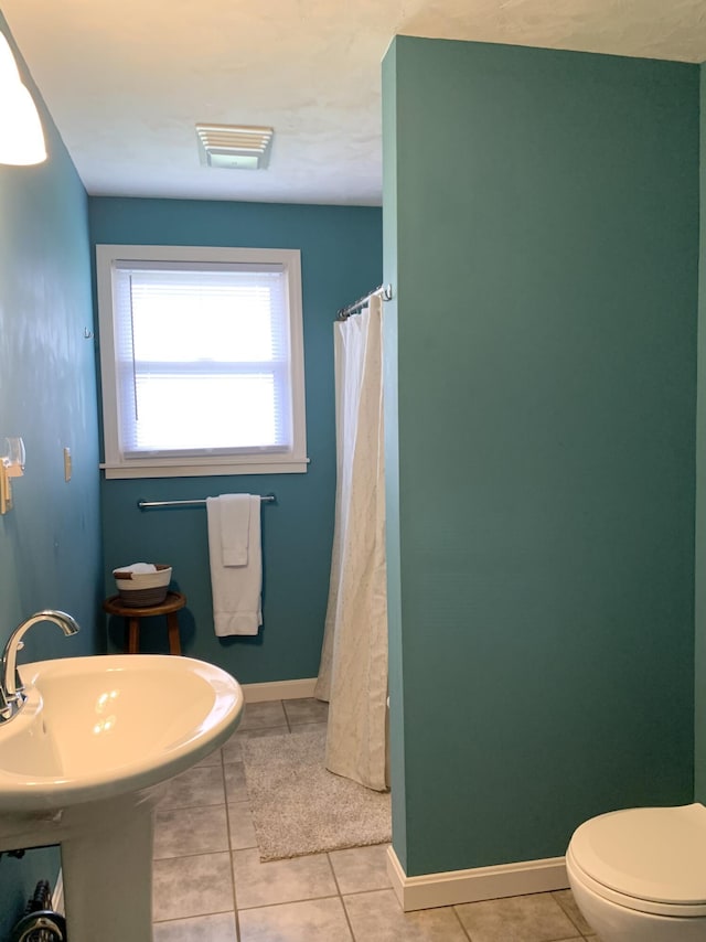 191 Water St, Eastport, ME 04631 - bathroom featuring tile patterned floors, toilet, baseboards, a shower with shower curtain, and a sink