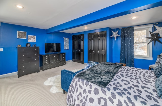 bedroom featuring recessed lighting, beam ceiling, two closets, baseboards, and carpet floors