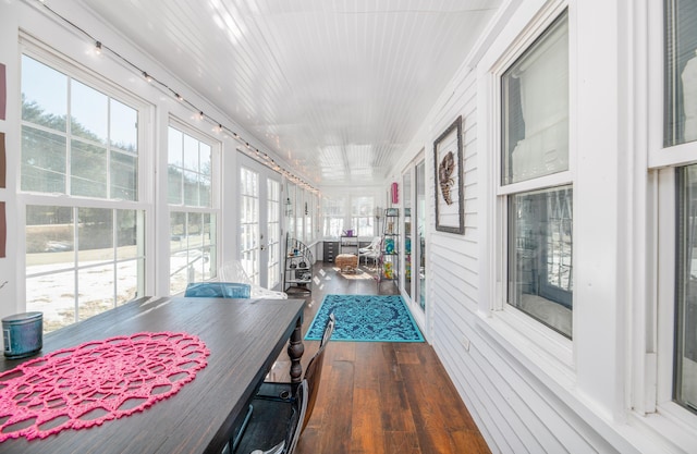 sunroom / solarium featuring wood finished floors and french doors