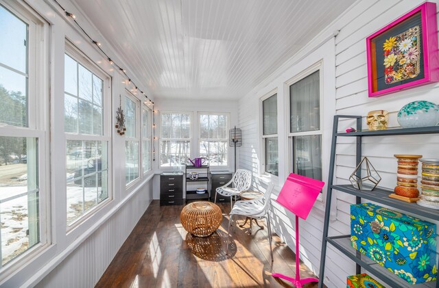 sunroom / solarium featuring wood finished floors and a healthy amount of sunlight