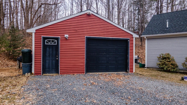 detached garage featuring gravel driveway