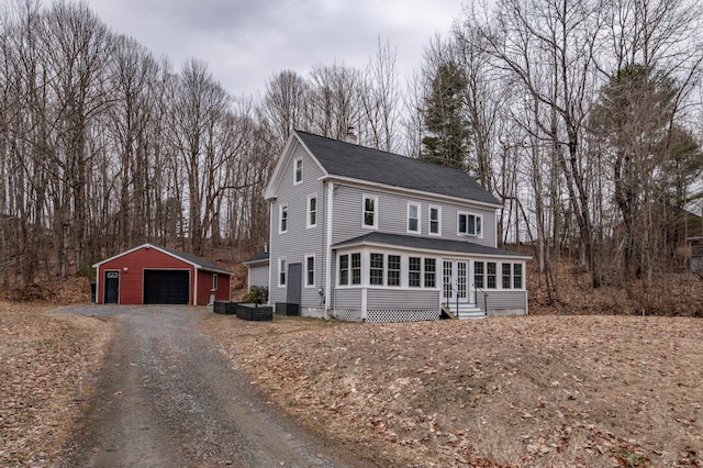 traditional-style home featuring an outdoor structure, entry steps, roof with shingles, french doors, and a garage