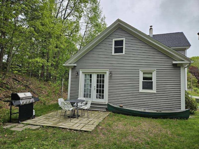 3 Adell Rd, Readfield, ME 04355 - back of property with a patio area, french doors, a chimney, entry steps, and a lawn
