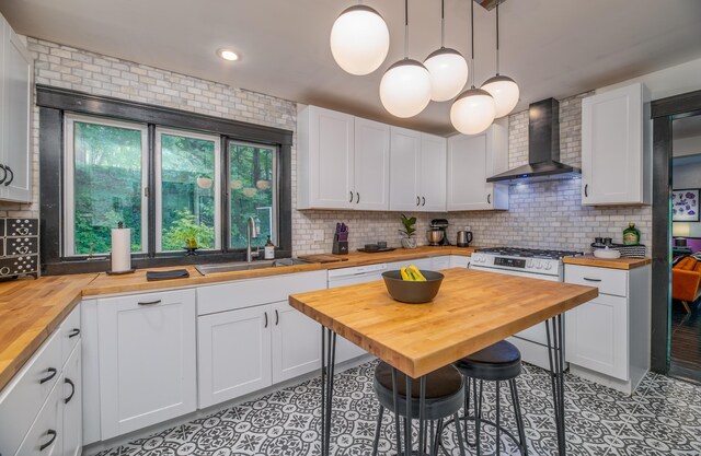 3 Adell Rd, Readfield, ME 04355 - kitchen with wooden counters, wall chimney range hood, gas range, light tile patterned floors, and recessed lighting
