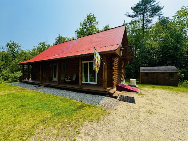 362 N Raymond Rd, Poland, ME 04274 - back of house with a storage shed, a lawn, log exterior, a metal roof, and a porch