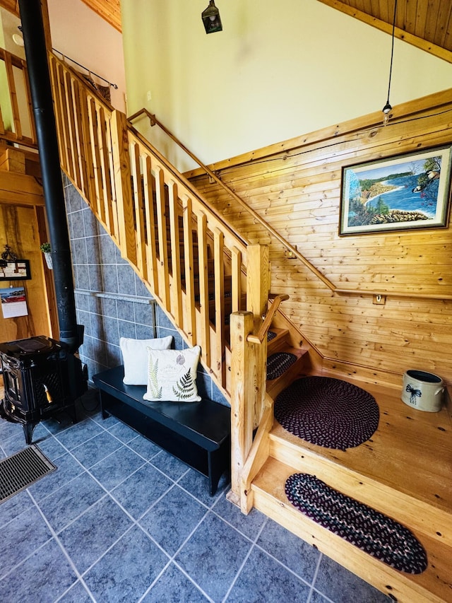 362 N Raymond Rd, Poland, ME 04274 - stairs featuring a wood stove, tile patterned floors, wooden walls, wooden ceiling, and vaulted ceiling