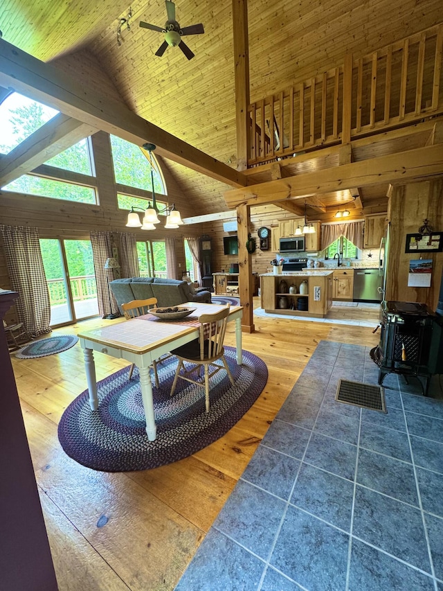 362 N Raymond Rd, Poland, ME 04274 - living area with high vaulted ceiling, a ceiling fan, light wood-type flooring, beamed ceiling, and a wood stove