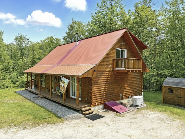 362 N Raymond Rd, Poland, ME 04274 - rear view of house featuring log exterior, a storage shed, a metal roof, and a porch