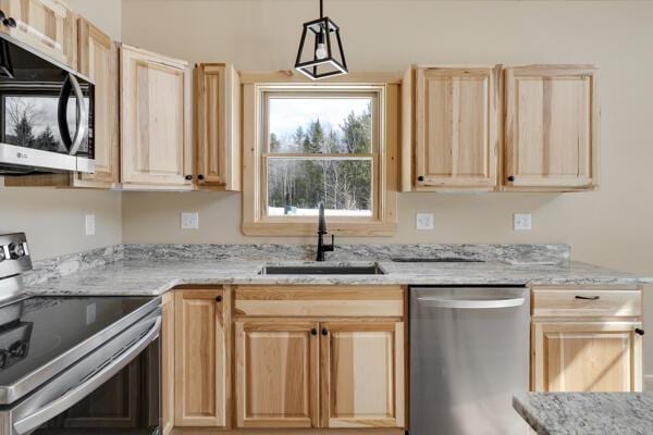 18 Thayer Way, Bethel, ME 04217 - kitchen with stainless steel appliances, light brown cabinetry, light stone countertops, and pendant lighting