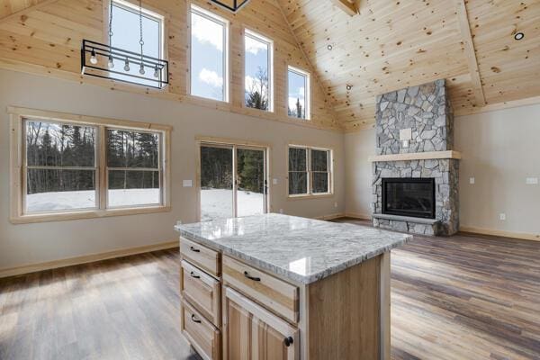 18 Thayer Way, Bethel, ME 04217 - kitchen with high vaulted ceiling, wood ceiling, wood finished floors, a fireplace, and light stone countertops