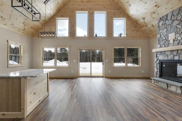 18 Thayer Way, Bethel, ME 04217 - unfurnished living room featuring high vaulted ceiling, wood ceiling, healthy amount of natural light, dark wood-style flooring, and a stone fireplace