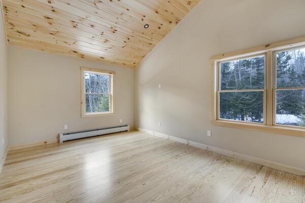 18 Thayer Way, Bethel, ME 04217 - unfurnished room with a baseboard heating unit, vaulted ceiling, wood ceiling, and wood finished floors