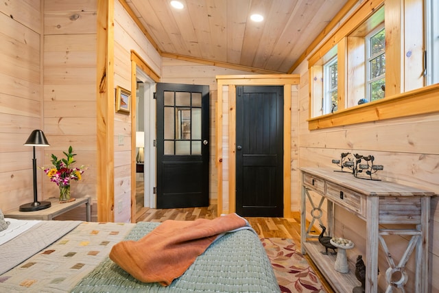 bedroom featuring light wood finished floors, vaulted ceiling, recessed lighting, wood ceiling, and wooden walls