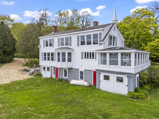 15 Church Ln, Phippsburg, ME 04562 - rear view of house featuring a sunroom, a chimney, a lawn, and a shingled roof
