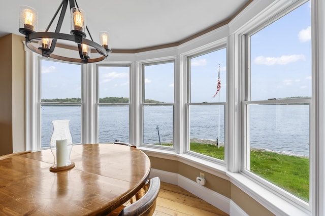 15 Church Ln, Phippsburg, ME 04562 - dining space featuring a chandelier, a water view, baseboards, and light wood-style floors