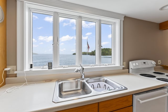 15 Church Ln, Phippsburg, ME 04562 - kitchen with white range with electric cooktop, a sink, dishwashing machine, light countertops, and brown cabinetry