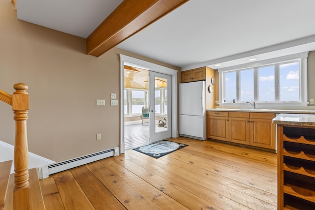 15 Church Ln, Phippsburg, ME 04562 - kitchen with freestanding refrigerator, baseboard heating, beam ceiling, light wood-style flooring, and a sink
