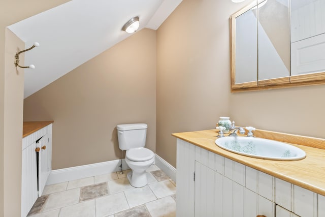 15 Church Ln, Phippsburg, ME 04562 - bathroom featuring vanity, toilet, baseboards, vaulted ceiling, and tile patterned flooring