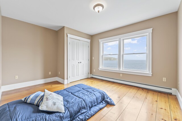 15 Church Ln, Phippsburg, ME 04562 - bedroom featuring baseboard heating, hardwood / wood-style flooring, a closet, and baseboards