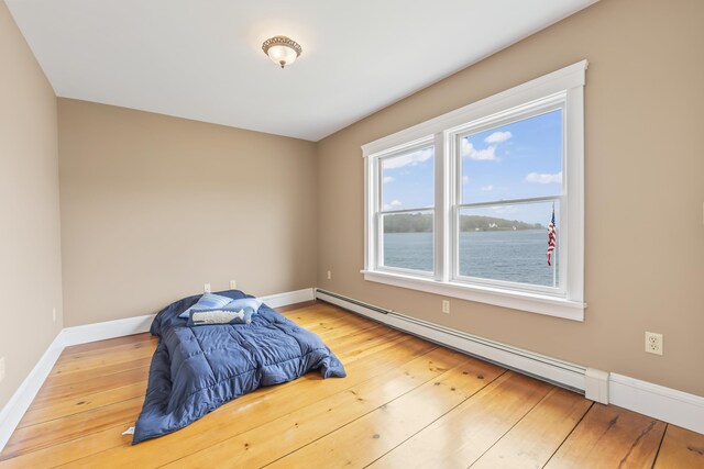 15 Church Ln, Phippsburg, ME 04562 - unfurnished bedroom featuring a baseboard radiator, baseboards, and wood finished floors